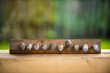 Summer background of railroad nails and wood. rhythmic composition. Against the background of a blurred bokeh of green leaves and a wooden fence