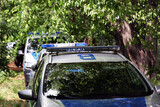 Fototapeta  - Radiowóz polskiej policji na teren zieleni w parku podczas akcji poszukiwanie. 

