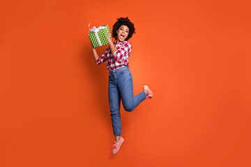 Sticker - Full length photo of crazy excited lady jump high hold present box wear shirt jeans isolated bright color background