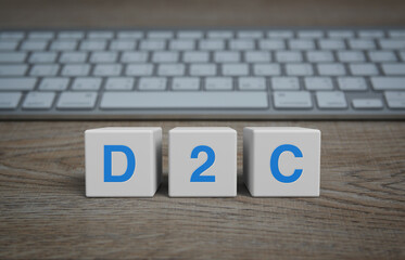 D2C letter on white block cubes on wooden table with modern computer keyboard, Direct to consumer online concept