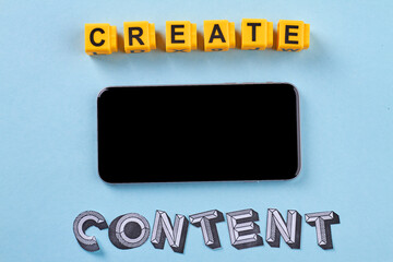 Flat lay smartphone and create content words. Isolated on blue background.