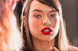 Make-up Artist Has Applied Red Lipstick on the Full Natural Lips of a Beautiful Caucasian Woman With Cat Blue Eyes Looking Away.