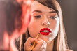 Make-up Artist Retouching the Red Lipstick on the Full Natural Lips of a Beautiful Caucasian Woman With Cat Blue Eyes and Open Mouth