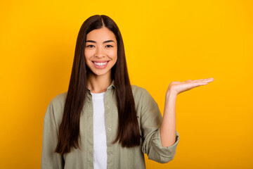 Photo of young adorable woman hold object on her hand promote black friday sales isolated on yellow color background