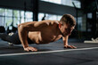 Man doing push ups in a gym. Exhaling and inhaling after push-ups and exercise. Perfect for fitness and workout. Young sports man performs pushups in the gym. The athlete is engaged in fitness