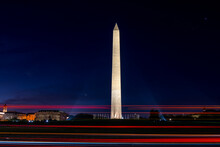View Of The Washington Monument At Night With Car Trails In The Foreground