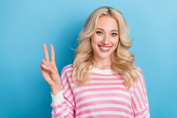 Poster - Photo of lovely millennial blond hairdo lady show v-sign wear striped shirt isolated on blue color background