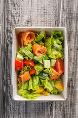 Wall Mural - Healthy food to go. Salad with salmon fish in takeaway container