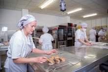 Woman With Baked Bread In Bakery School