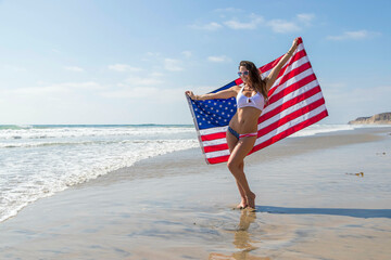 A Lovely Patriotic Brunette Model Poses On The Coast With An American Flag