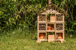 Insect house in the garden. Bug hotel at the park with plants in Switzerland.