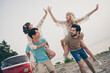 Photo of young company friends piggyback clap arms near sea minivan holiday trip wear hippie cloth outdoors outside