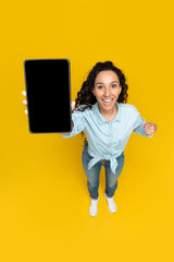 Poster - Cheerful young lady pointing at tablet pc with blank screen, recommending mobile app, advertising your website, mockup