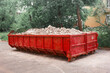 Red container with solid domestic and construction waste. Caring for the environment