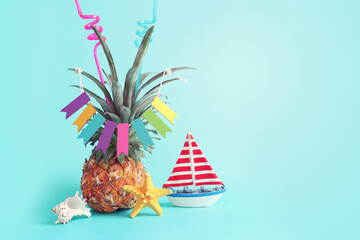 Wall Mural - Image with ripe pineapple with parasol over blue background. Summer holidays and tropical theme