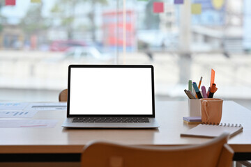 Poster - Workplace desk with a laptop with a white blank screen, note books and pencils, for business and technology concept.