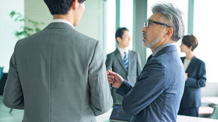 Aufkleber - 若いビジネスマンと会話するエグゼクティブ男性