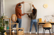 © Prostock-studio - Black Millennial Spouses Hanging Poster On Wall Together At Home