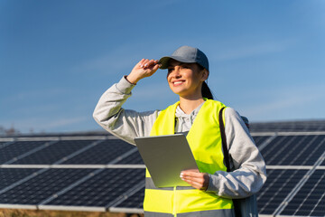 female energy specialist looking away with happy smile after using digital tablet for reading inform