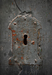 Fototapete - Antique keyhole of an old lock on a wooden background.  Concept and idea on the topic of security, history, protection, guard, secret etc. Rusty lock and keyhole  in a wooden door.