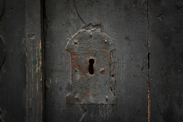 Fototapete - Antique keyhole of an old lock on a wooden background.  Concept and idea on the topic of security, history, protection, guard, secret etc. Rusty lock and keyhole  in a wooden door.