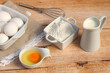 Grundnahrungsmittel Milch,Eier und Mehl auf einem Holztisch.