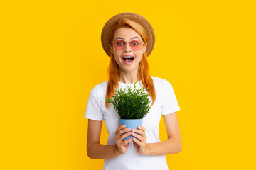 Wall Mural - Portrait of gorgeous girl holds pots with exotic sprout. Beautiful lady in gardening outfit smiling. Pretty model working, summer gardening concept. Woman planting flowers in pot.