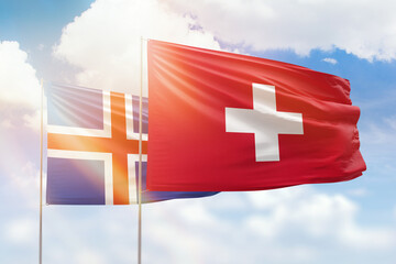 Sunny blue sky and flags of switzerland and iceland