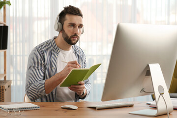 Wall Mural - Online test. Man studying with computer at home