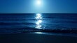 Moonlight reflecting over dark blue sea and soft waves are sparkling waves lapping on beach at night. Cinematic slow motion RED camera shot with blue water background with copy space for commercial
