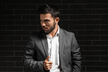 Poster - Fashionable bearded businessman looking aside on dark background