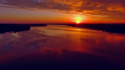 Wall Mural - Spectacular red dawn sky mirrored in tranquil waters, dynamic moving perspective.
