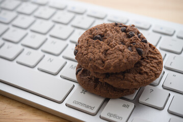 Chocolate chip cookies on keyboard computer background copy space. Cookies website internet homepage policy accpeted or blocks concept.