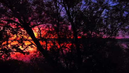 Wall Mural - Spectacular red dawn sky mirrored in tranquil waters, dynamic moving perspective.
