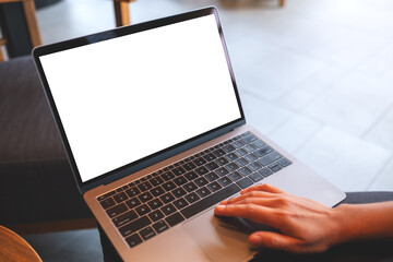 Wall Mural - mockup image of a woman working and touching on laptop touchpad with blank white desktop screen