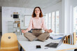 © contrastwerkstatt - business woman does yoga on desk in office and relaxes