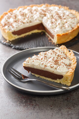 Canvas Print - Rich piece chocolate pie with a coconut haupia layer and topped with whipped cream closeup in the plate on the table. Vertical