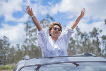 Happy Hispanic Woman Peeking From Car Sunroof