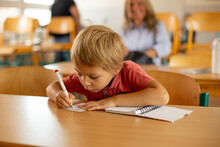 Preschool Child, Sitting On A Desk At School, Having Lesson, Learning