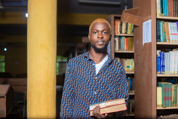 Wall Mural - close up of a handsome male reading books in the library