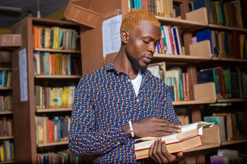 young man reading book in library