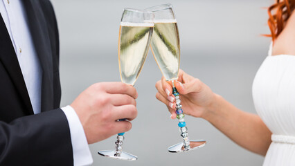 Sticker - closeup hands of the bride and groom with glasses of champagne