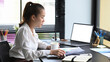 © Prathankarnpap - Asian businesswoman managing company operations, analyzing commerce data, marketing plans at office desk