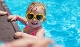 Fototapeta  - Baby swims in the pool. Selective focus.