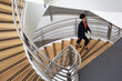 © ReeldealHD images - African American businesswoman walking up spiral staircase in office