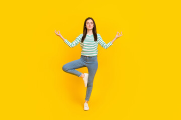 Wall Mural - Full body image of beautiful charming woman practice mindfulness doing yoga isolated on yellow color background