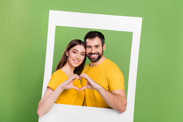 Poster - Photo of two lovely cheerful people hands showing heart symbol paper album card window isolated on green color background