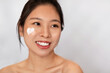 © Prostock-studio - Facial skincare. Happy korean lady with heart-shaped moisturizer cream on face posing over white background, copy space