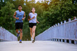 © Panumas - Young couple running together on road across the bridge. Couple, fit runners fitness runners during outdoor workout.