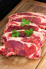 five raw steaks of sirloin beef. top grade premium quality meat on wooden cutting board, vetical shot.